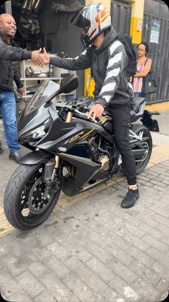 Cliente saindo da oficina em moto esportiva preta